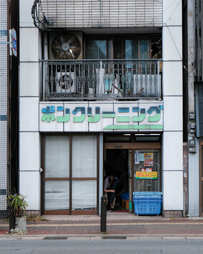 Street view of a laundry shop in an urban setting with Japanese signage and outdoor decor.